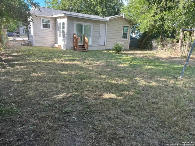 a backyard of a house with large trees and trees