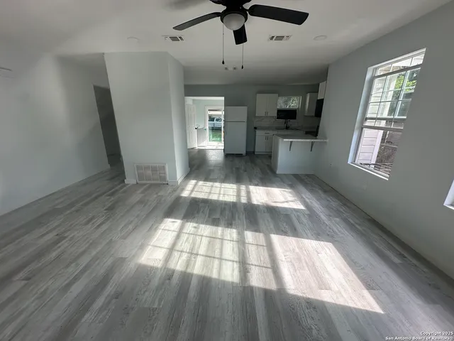 a view of empty room with wooden floor and windows