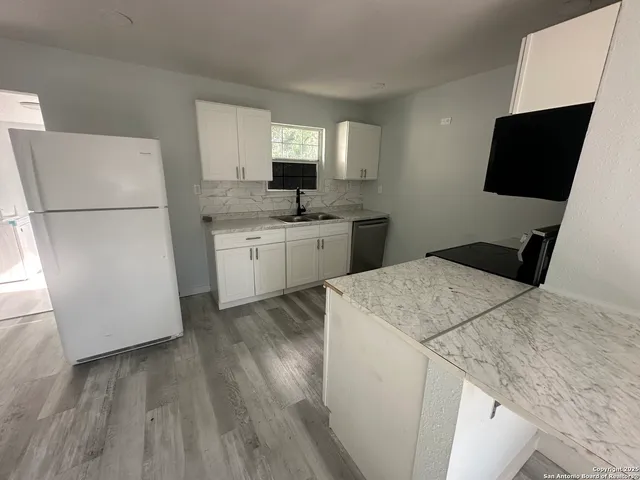 a kitchen with a sink cabinets and window