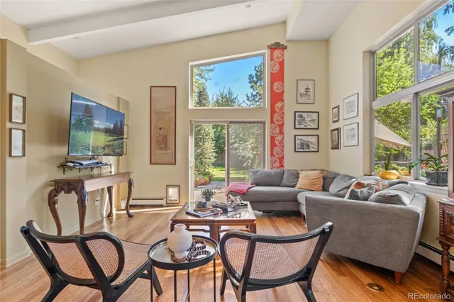 a living room with furniture a flat screen tv and a floor to ceiling window