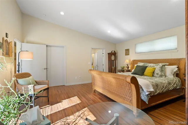 a spacious bedroom with a bed and chair