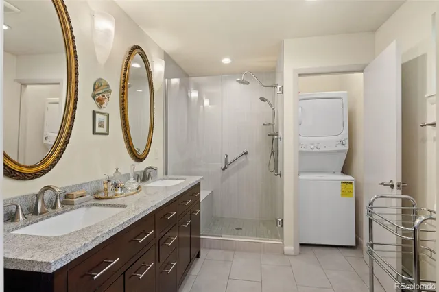 a bathroom with a granite countertop sink a mirror and a shower