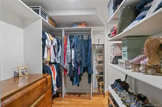 a view of walk in closet with clothes and shoes