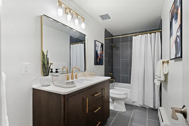 a bathroom with a sink toilet double vanity and shower