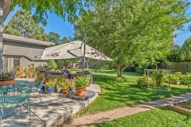 a view of a lake with a table and chairs under an umbrella