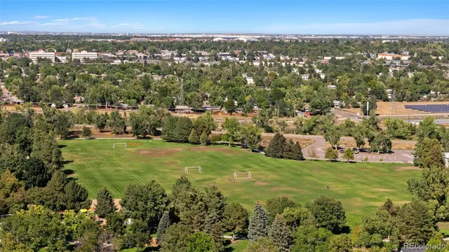 an aerial view of residential houses with outdoor space and trees