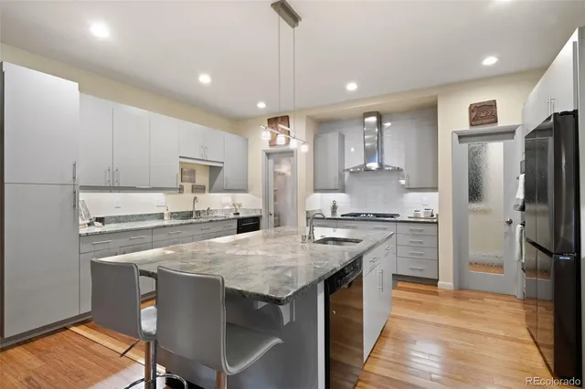 a kitchen with stainless steel appliances granite countertop a stove refrigerator sink and cabinets
