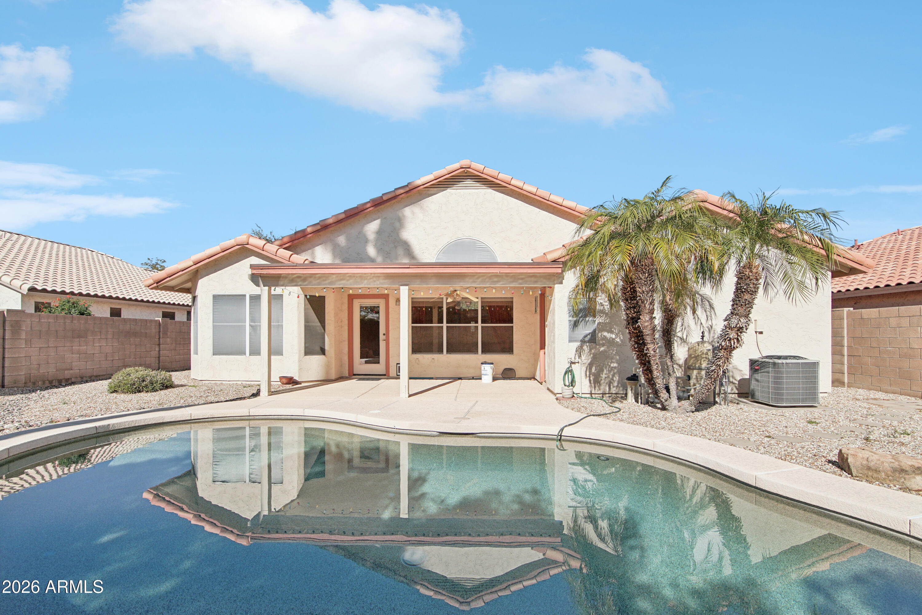 a view of a house with pool and sitting area