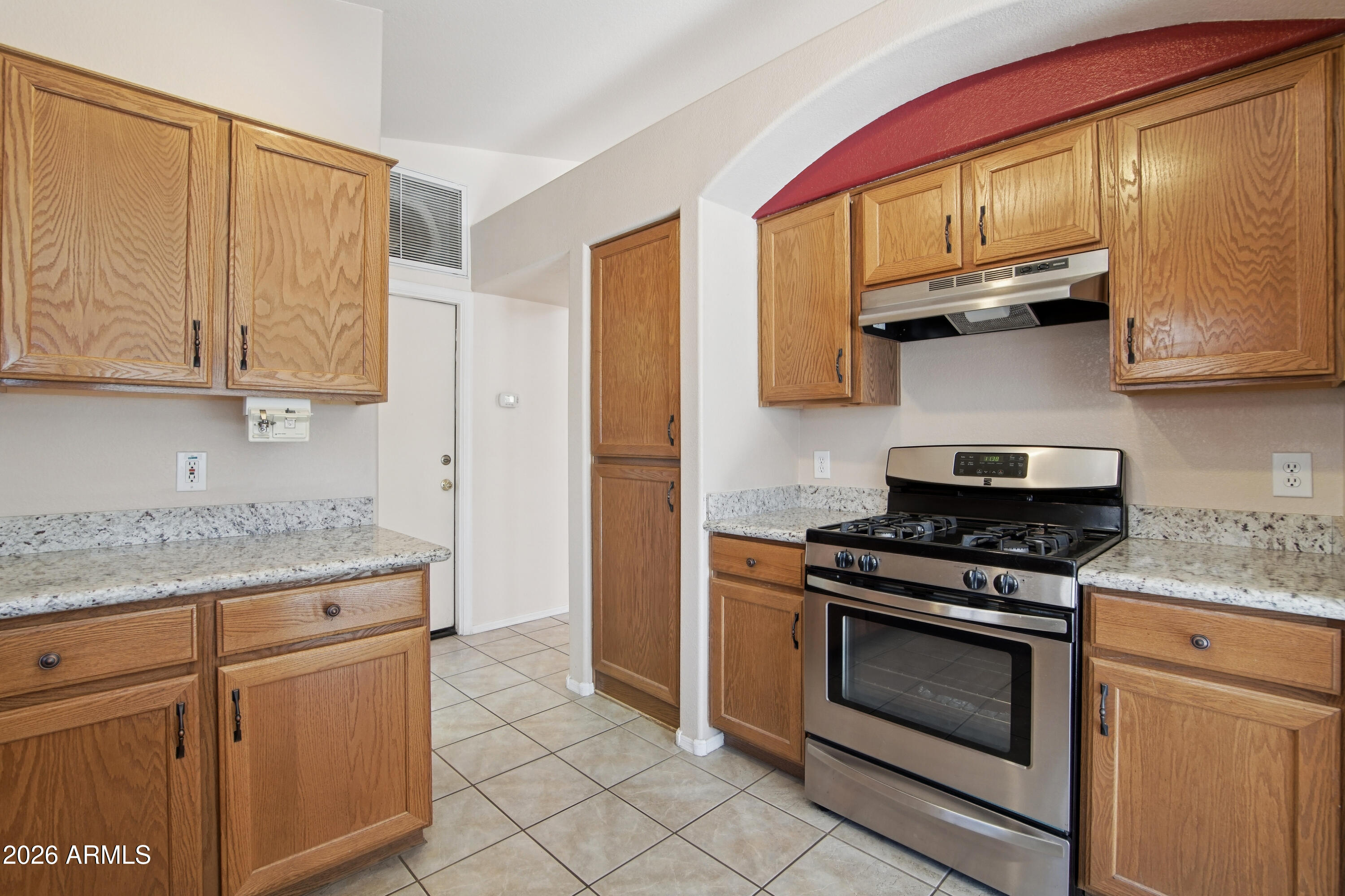 9729 West Burnett Road Peoria, AZ 85382 - Photo 11 of 29 a kitchen with stainless steel appliances granite countertop a stove a sink and a microwave