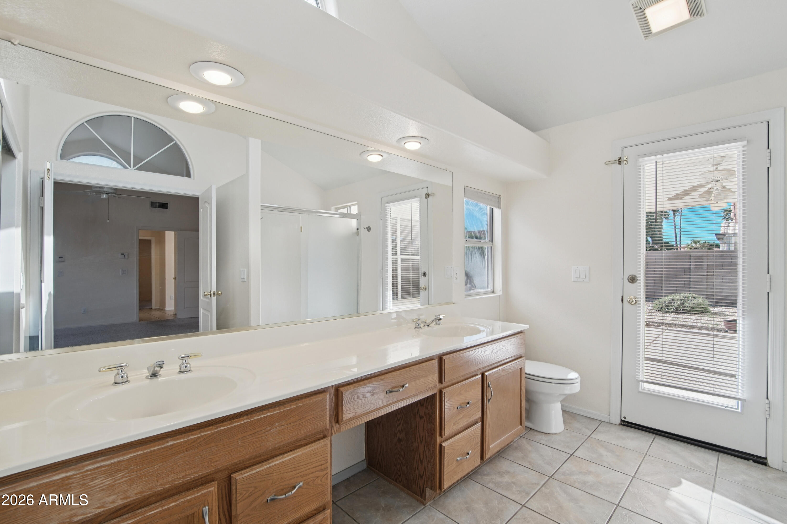 9729 West Burnett Road Peoria, AZ 85382 - Photo 15 of 29 a bathroom with a double vanity sink a toilet and a mirror