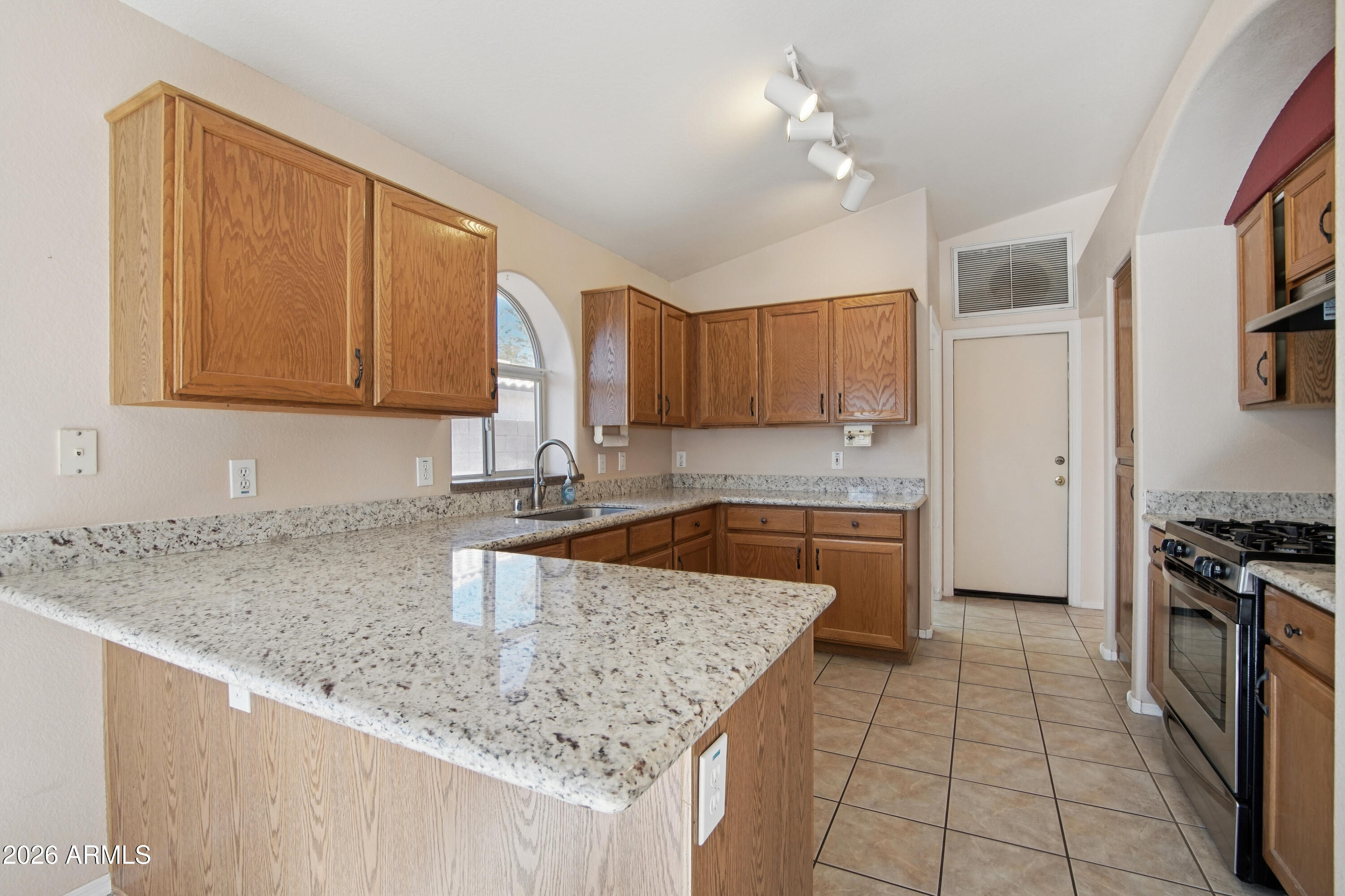 9729 West Burnett Road Peoria, AZ 85382 - Photo 8 of 29 a kitchen with stainless steel appliances granite countertop a sink stove and cabinets