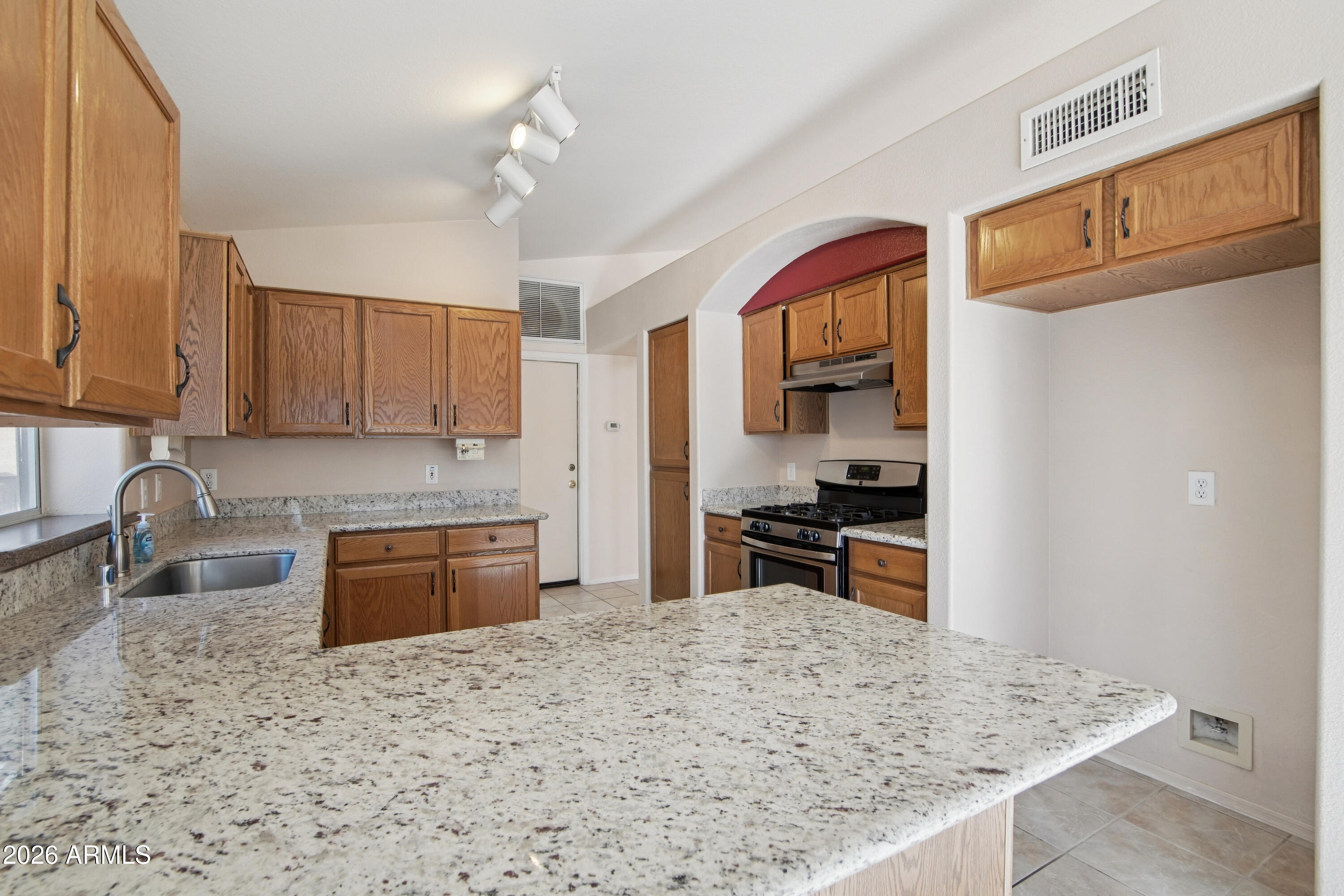 9729 West Burnett Road Peoria, AZ 85382 - Photo 9 of 29 a kitchen with granite countertop a sink stove and refrigerator