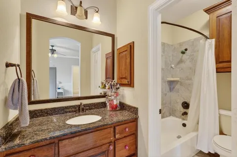 a bathroom with a granite countertop sink vanity mirror shower and a bathtub