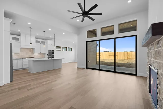 a view of an empty room with kitchen appliances and a window
