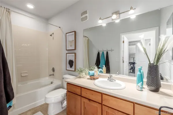 a bathroom with double vanity a toilet a a mirror a bathtub and shower