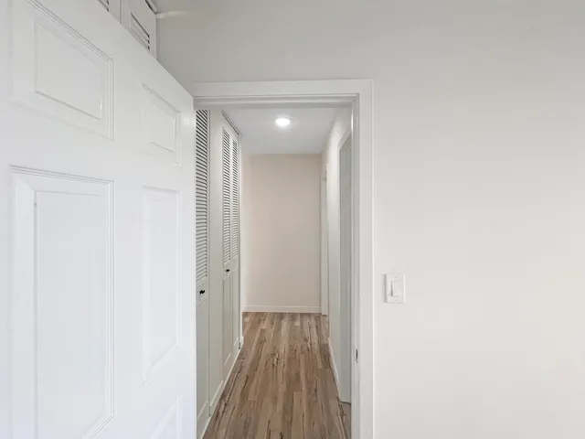a view of hallway with wooden floor