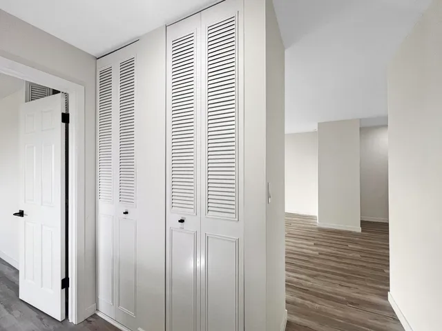 a view of a room with wooden floor and a bathroom