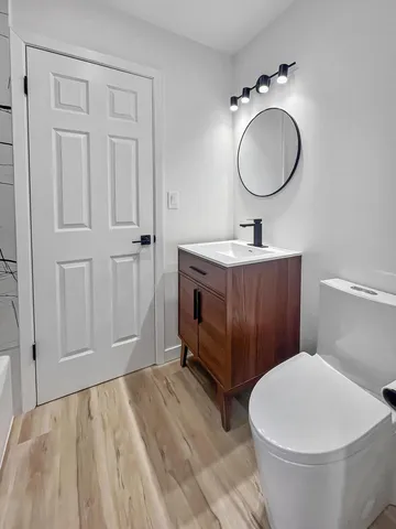 a bathroom with a toilet a sink and mirror
