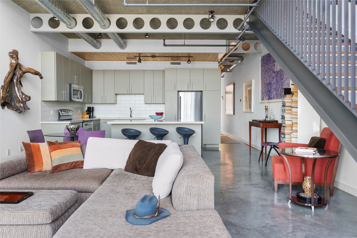 1401 Eva Street, Unit 406 Austin, TX 78704 - Photo 12 of 32 Exposed steel beams and piping with two storied open living room give a true loft experience.