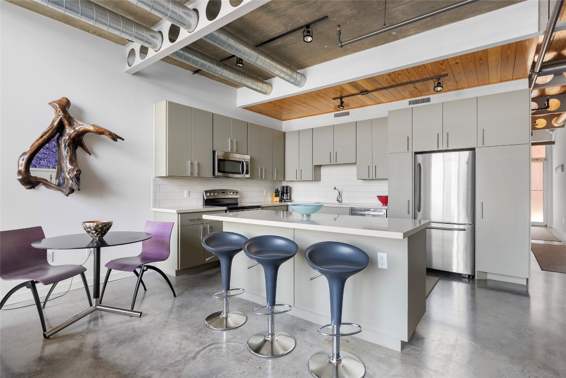 1401 Eva Street, Unit 406 Austin, TX 78704 - Photo 16 of 32 a kitchen with stainless steel appliances granite countertop a sink and a refrigerator