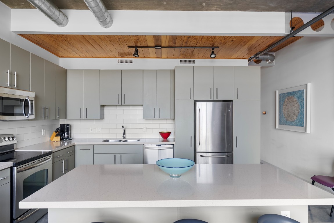 1401 Eva Street, Unit 406 Austin, TX 78704 - Photo 18 of 32 a kitchen with stainless steel appliances a refrigerator and a sink