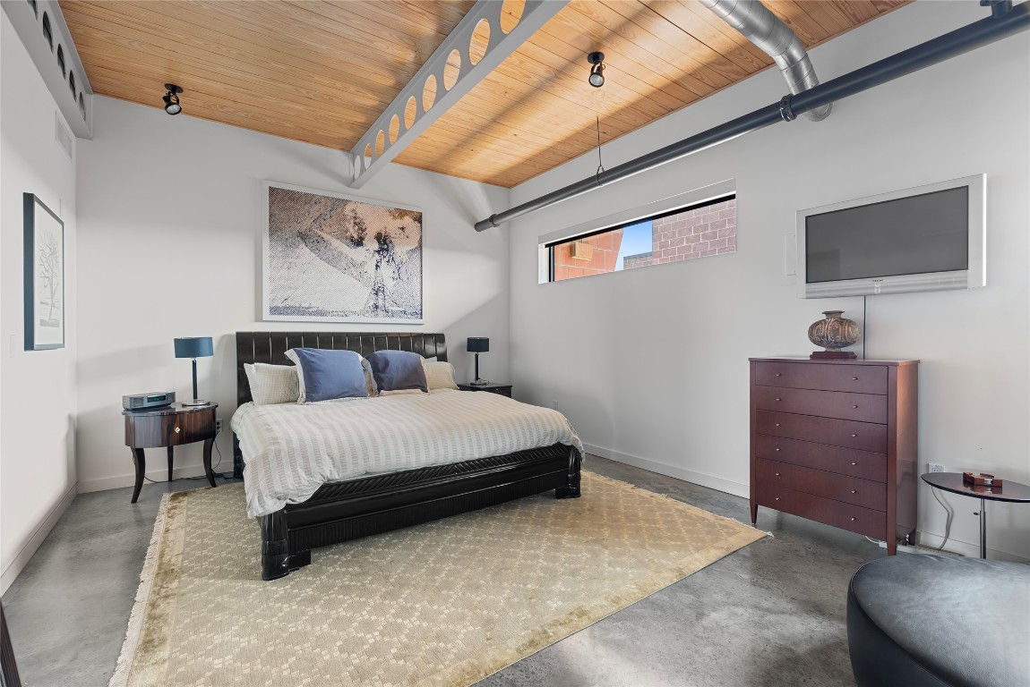 1401 Eva Street, Unit 406 Austin, TX 78704 - Photo 26 of 32 a spacious bedroom with a bed and a flat screen tv