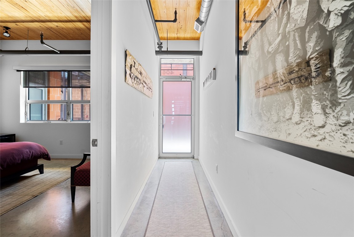 1401 Eva Street, Unit 406 Austin, TX 78704 - Photo 8 of 32 a view of a hallway to a livingroom with furniture and wooden floor