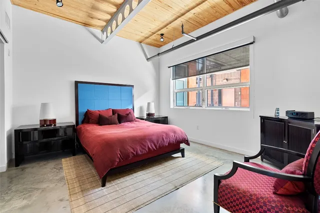 a bedroom with a bed a chandelier and a window