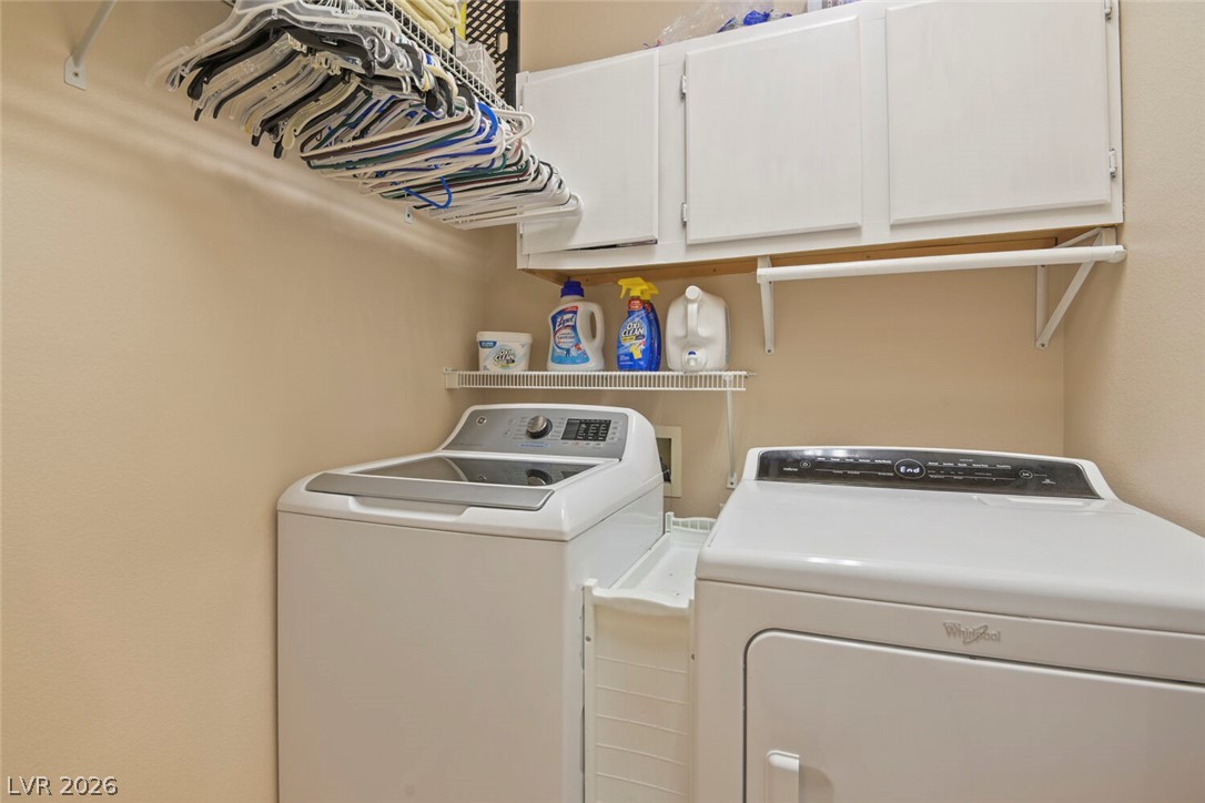 2356 Tilden Way Henderson, NV 89074 - Photo 15 of 30 A well-appointed laundry room features a convenient hanging rack and practical cabinet storage.