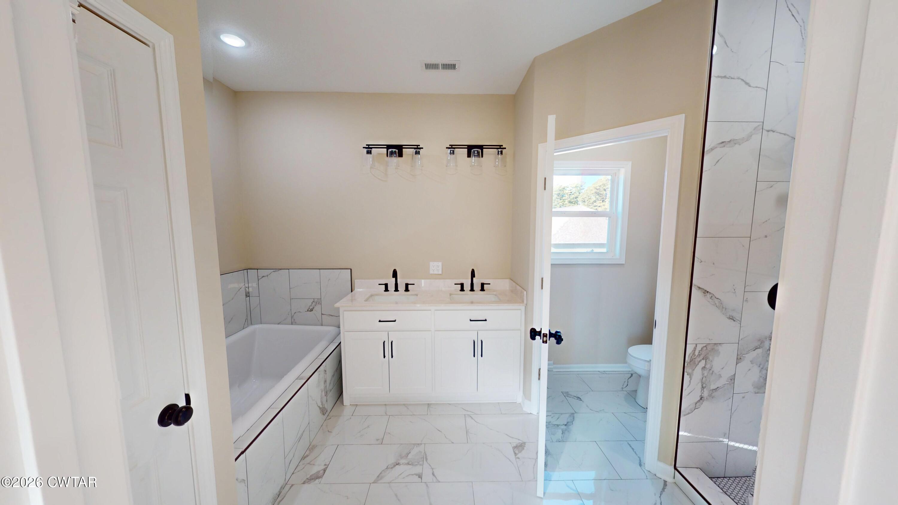 1360 Bonicord Road Dyersburg, TN 38024 - Photo 17 of 31 a bathroom with a tub sink and mirror