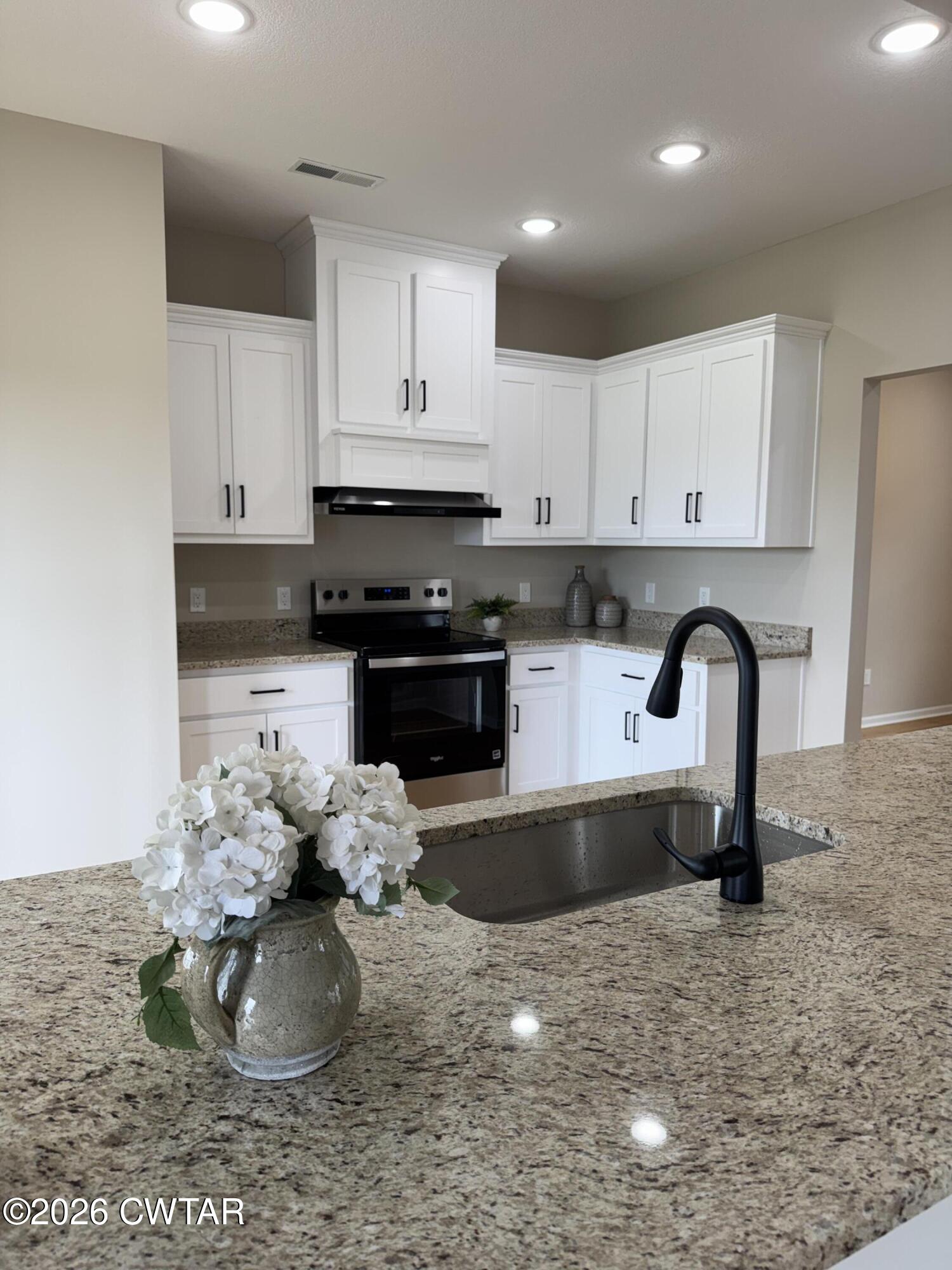1360 Bonicord Road Dyersburg, TN 38024 - Photo 29 of 31 a kitchen with stainless steel appliances granite countertop a stove a sink and a white cabinets