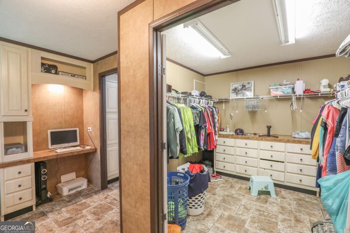 143 Mccullar Weaver Road Southwest Milledgeville, GA 31061 - Photo 13 of 28 a view of walk in closet with clothes and shoes