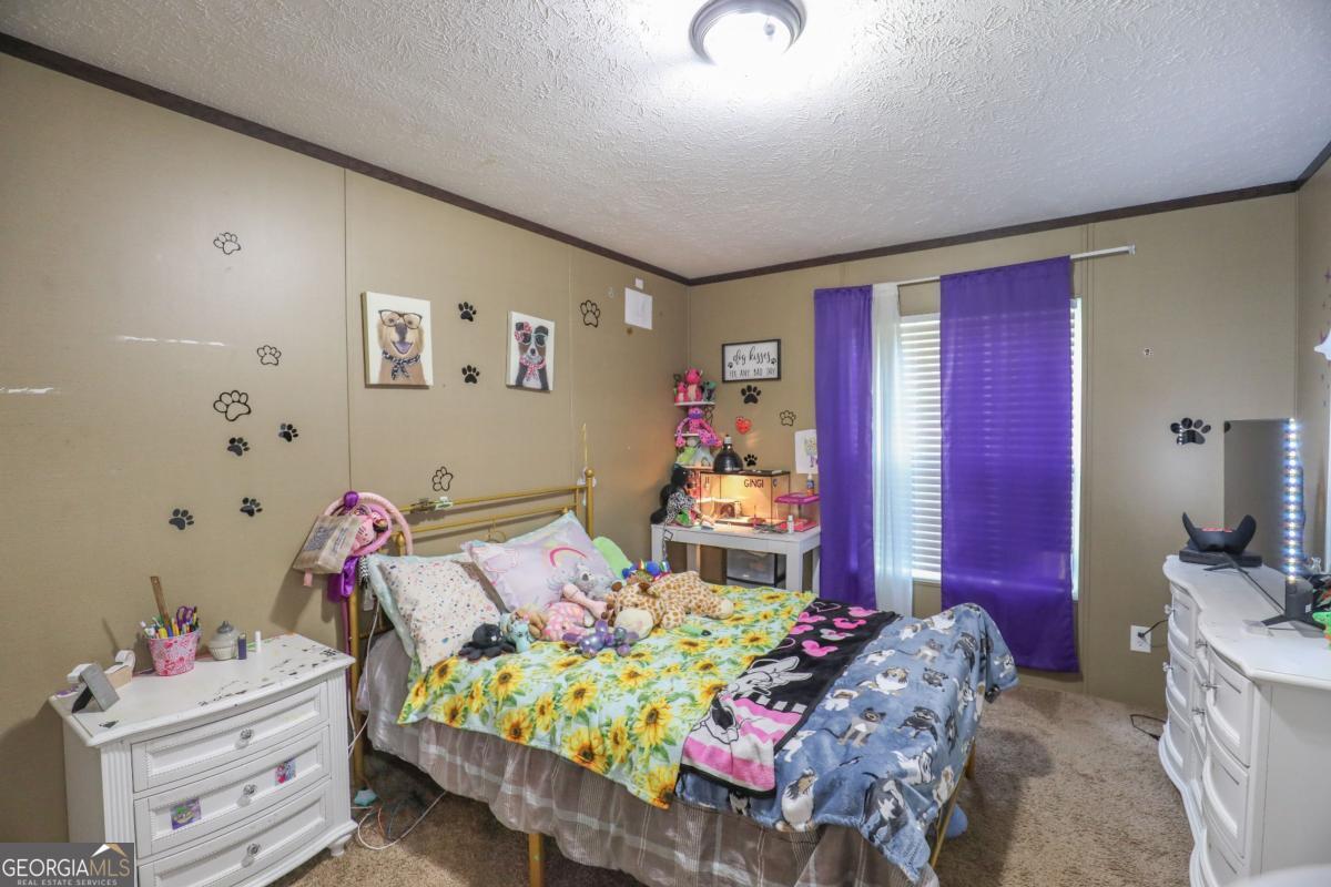 143 Mccullar Weaver Road Southwest Milledgeville, GA 31061 - Photo 16 of 28 a bedroom with a bed and a dresser in it