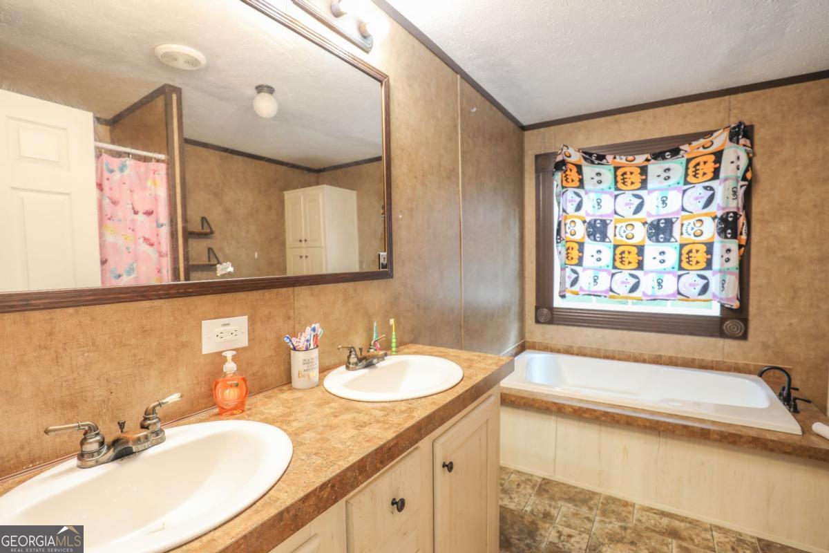143 Mccullar Weaver Road Southwest Milledgeville, GA 31061 - Photo 18 of 28 a bathroom with a granite countertop sink and a mirror