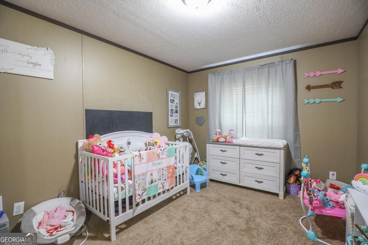 143 Mccullar Weaver Road Southwest Milledgeville, GA 31061 - Photo 20 of 28 a bedroom with a bed and a window