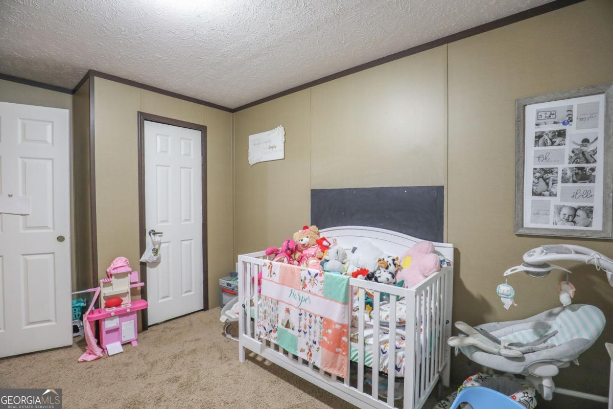 143 Mccullar Weaver Road Southwest Milledgeville, GA 31061 - Photo 21 of 28 a bedroom with a bed and a window