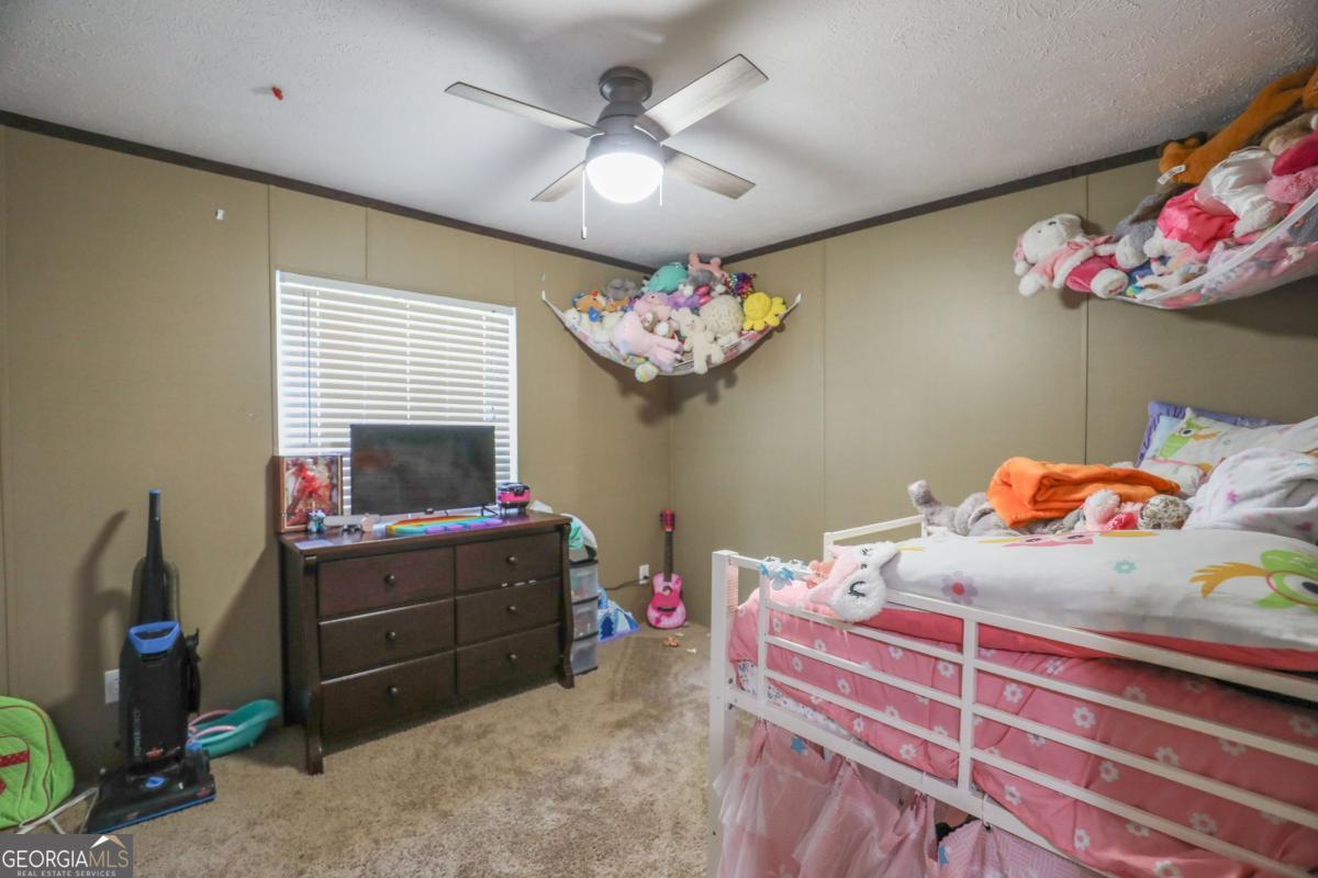 143 Mccullar Weaver Road Southwest Milledgeville, GA 31061 - Photo 22 of 28 a bedroom with a bed and wooden floor