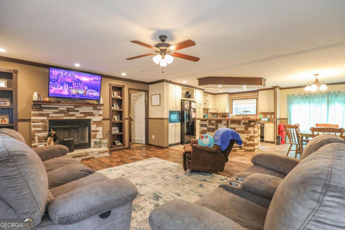 143 Mccullar Weaver Road Southwest Milledgeville, GA 31061 - Photo 3 of 28 a living room with furniture a fireplace and a flat screen tv