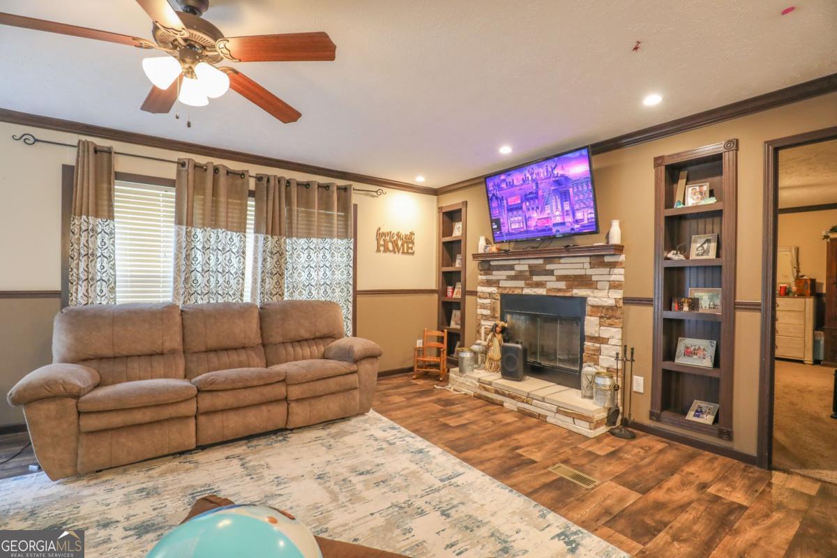 143 Mccullar Weaver Road Southwest Milledgeville, GA 31061 - Photo 4 of 28 a living room with fireplace furniture and a flat screen tv