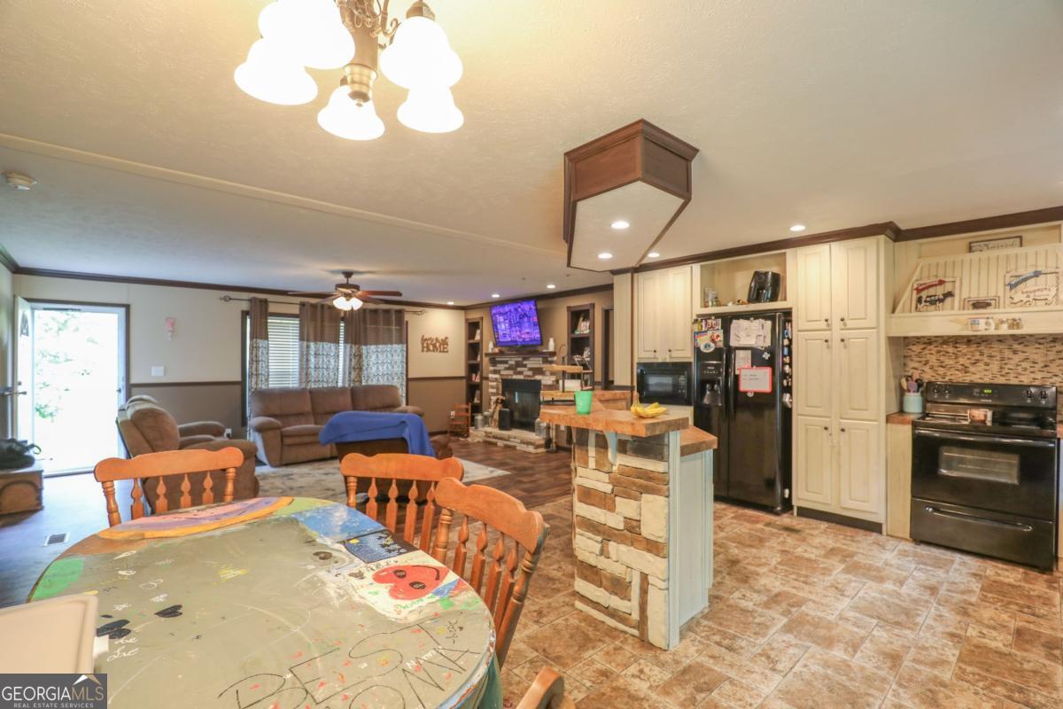 143 Mccullar Weaver Road Southwest Milledgeville, GA 31061 - Photo 8 of 28 a view of a dining room and livingroom with furniture wooden floor a chandelier