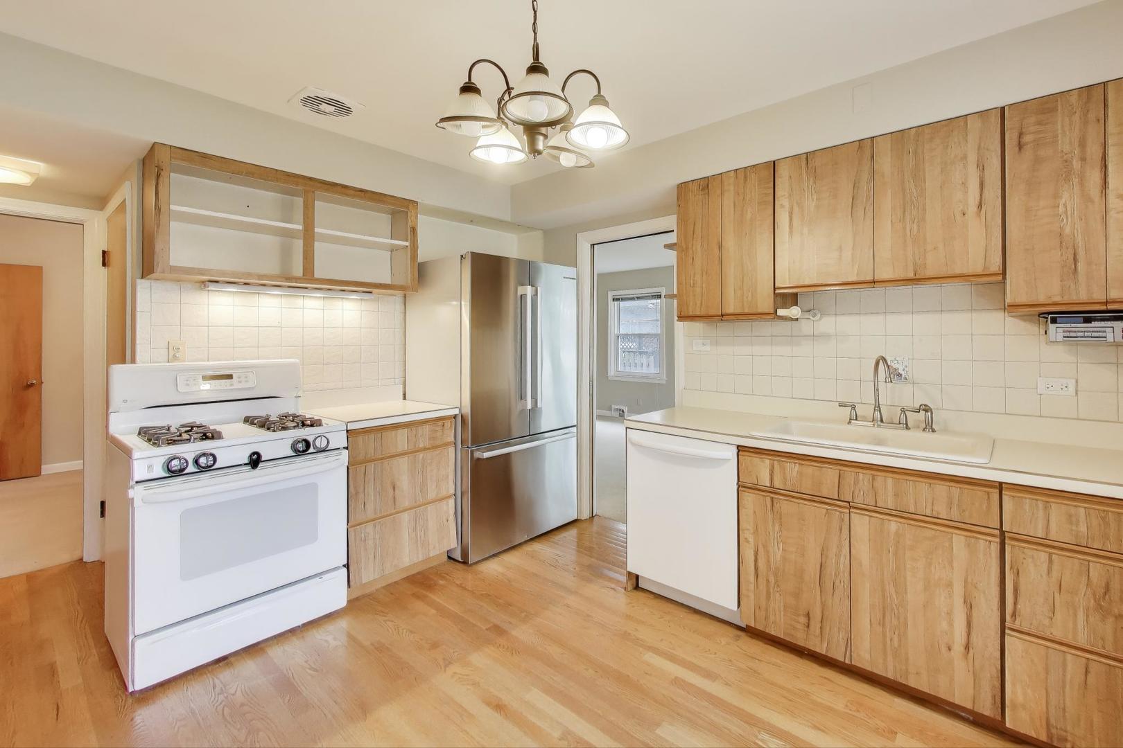 507 North Hamlin Avenue Park Ridge, IL 60068 - Photo 7 of 30 a kitchen with stainless steel appliances granite countertop a stove a sink dishwasher a refrigerator and white cabinets with wooden floor