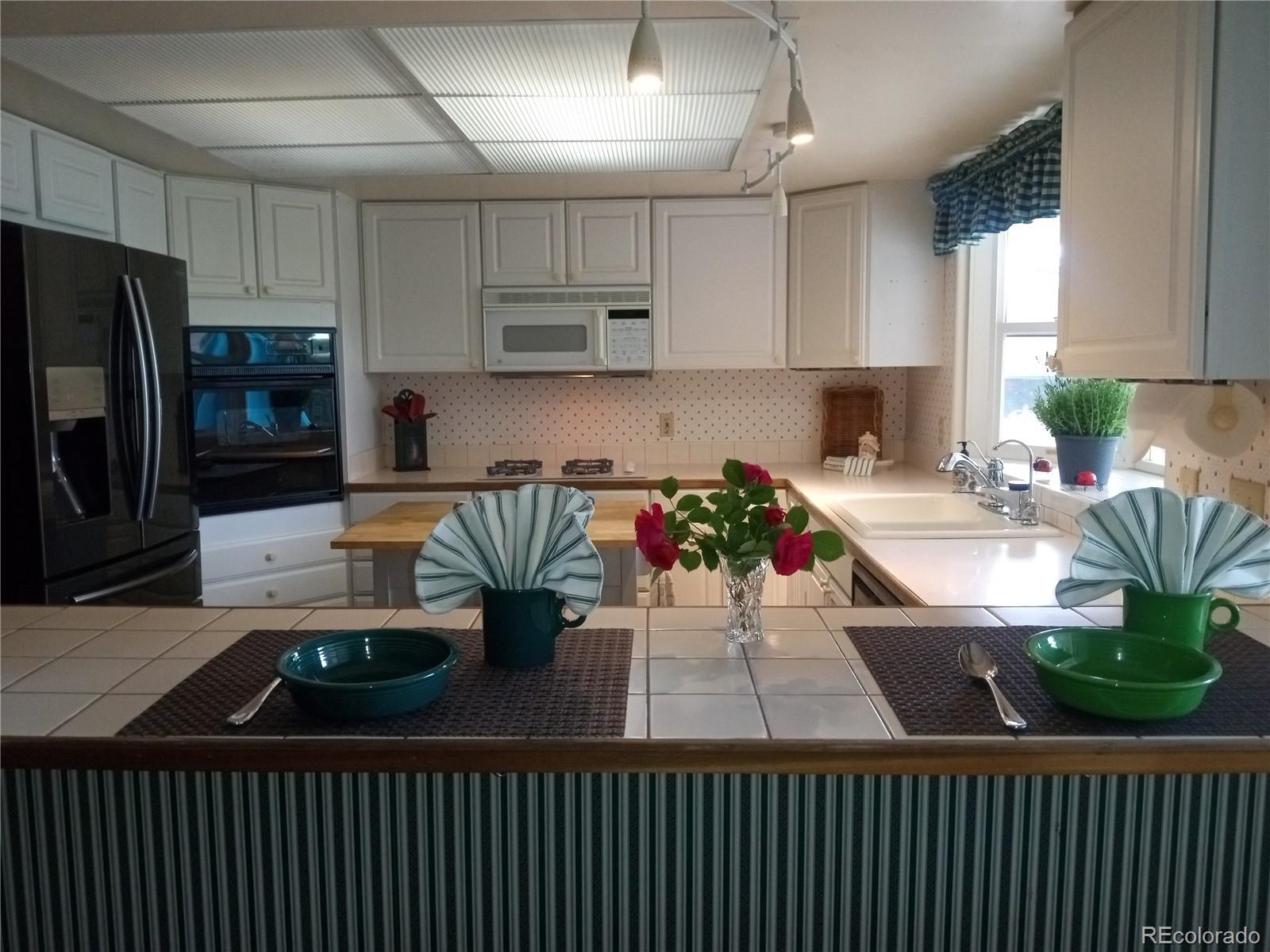 7150 South Platte Canyon Road Littleton, CO 80128 - Photo 27 of 37 a kitchen with a sink a stove and chairs