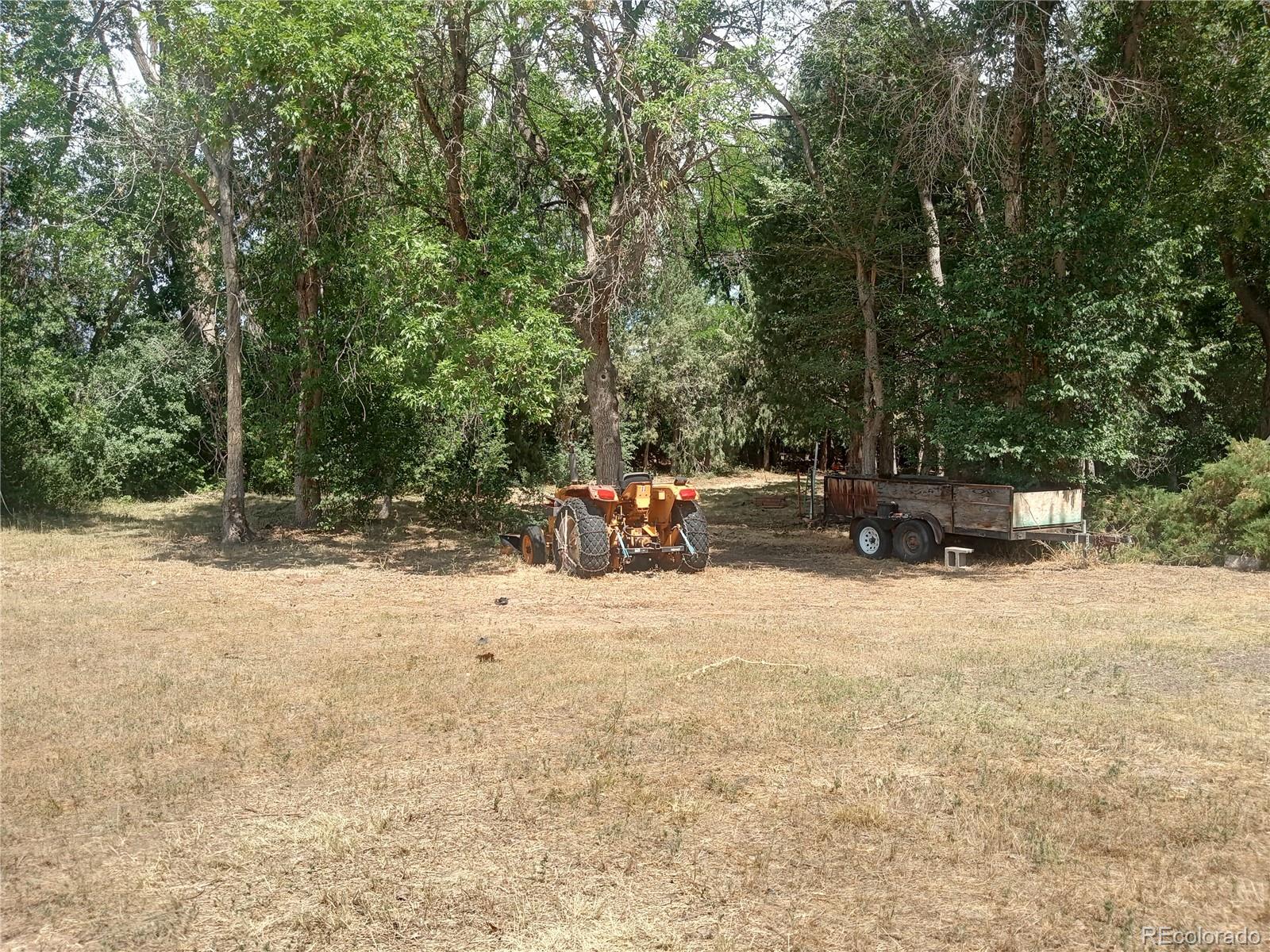 7150 South Platte Canyon Road Littleton, CO 80128 - Photo 7 of 37 a backyard of a house with a parked car
