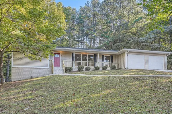 a front view of house with yard and trees in the background