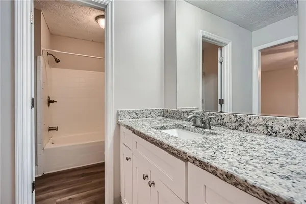 a bathroom with a granite countertop sink and a mirror