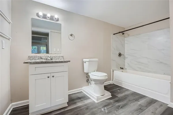 a bathroom with a granite countertop sink toilet and shower