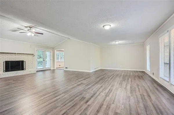 a view of empty room with wooden floor and fireplace
