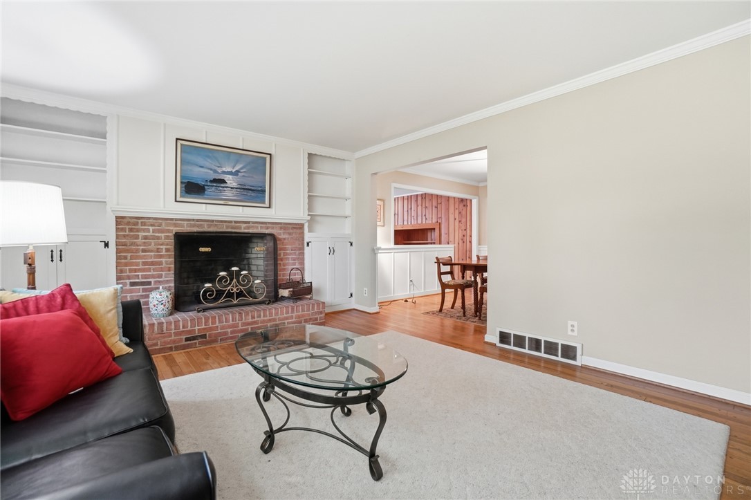 6119 Flemington Road Dayton, OH 45459 - Photo 9 of 76 This inviting living area features a classic brick fireplace, creating a warm and welcoming atmosphere.