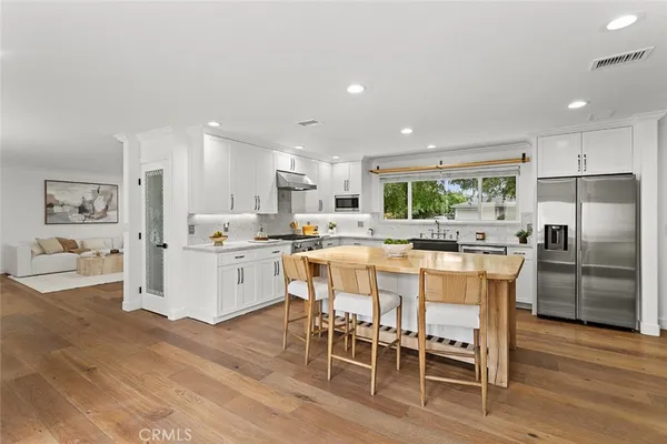 a kitchen with a dining table chairs refrigerator and cabinets