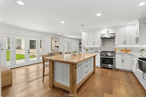 a large kitchen with stainless steel appliances granite countertop a stove and cabinets